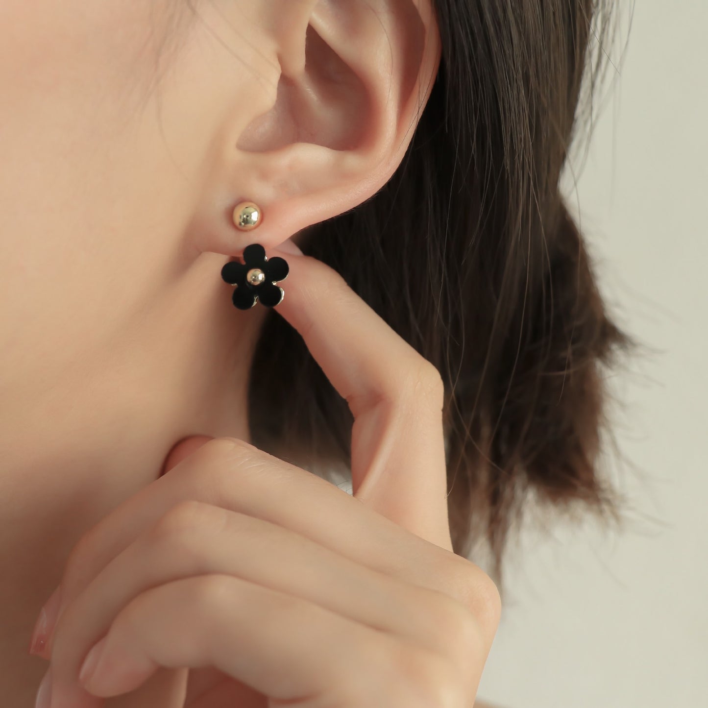 Boucles d'oreilles noires à petite fleur et mini marguerite sur le devant