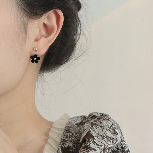 Boucles d'oreilles noires à petite fleur et mini marguerite sur le devant